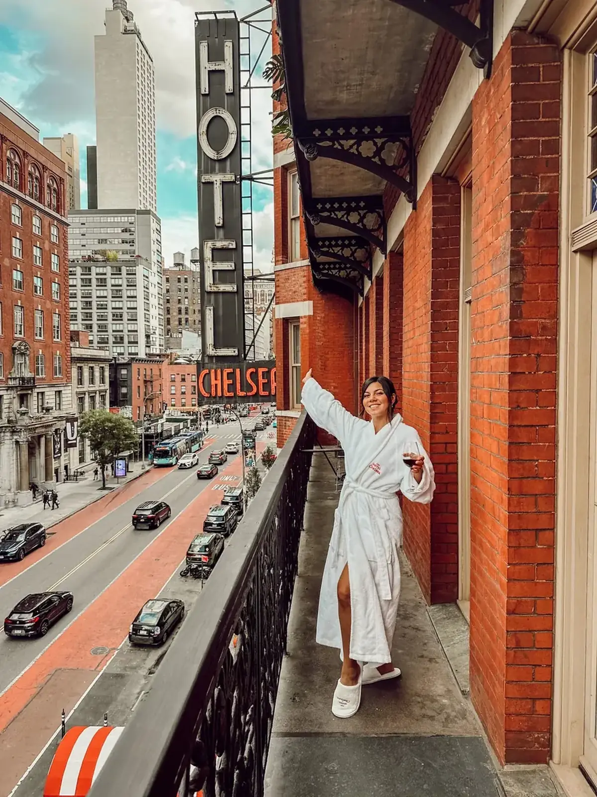 Model in a white robe on a European city hotel balcony